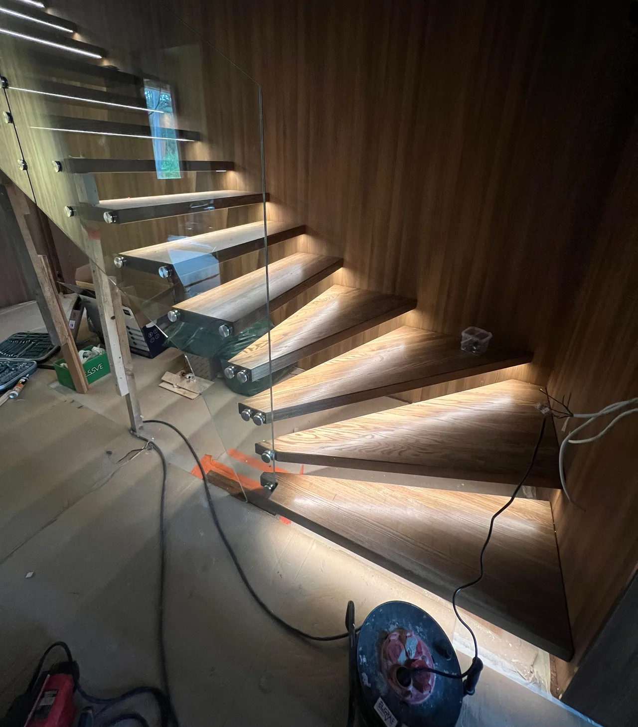 LED light lines beneath wooden stair treads during installation