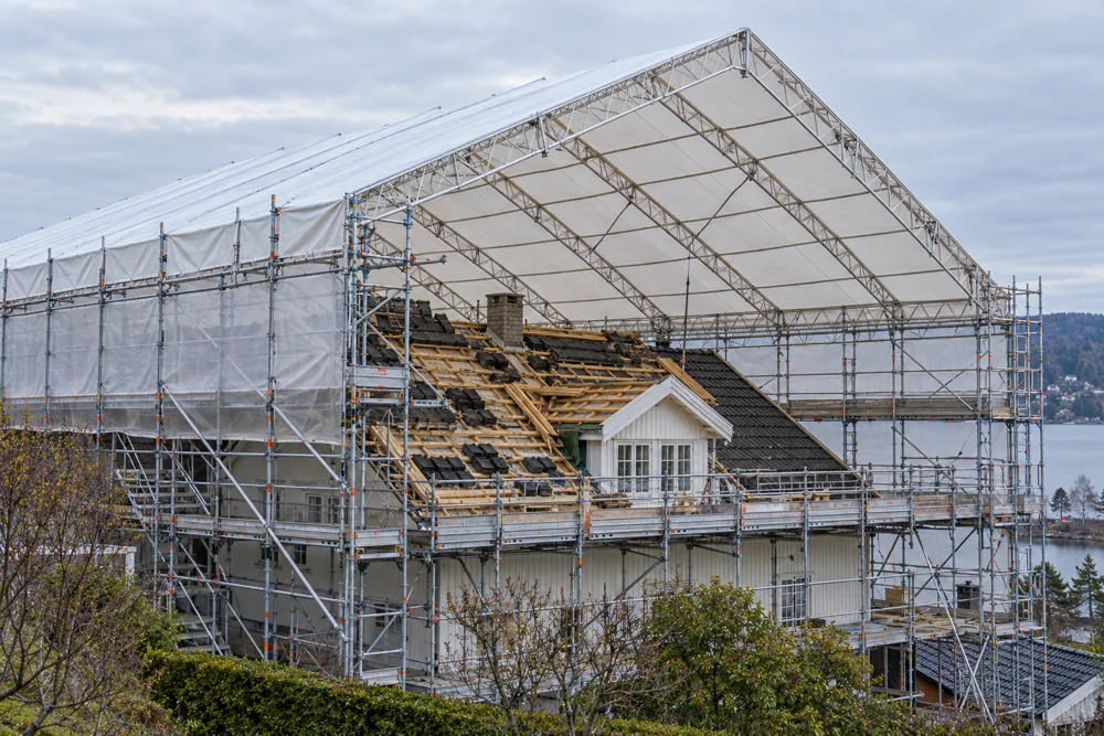Temporary weather-protection roof above a building, supported by scaffolding